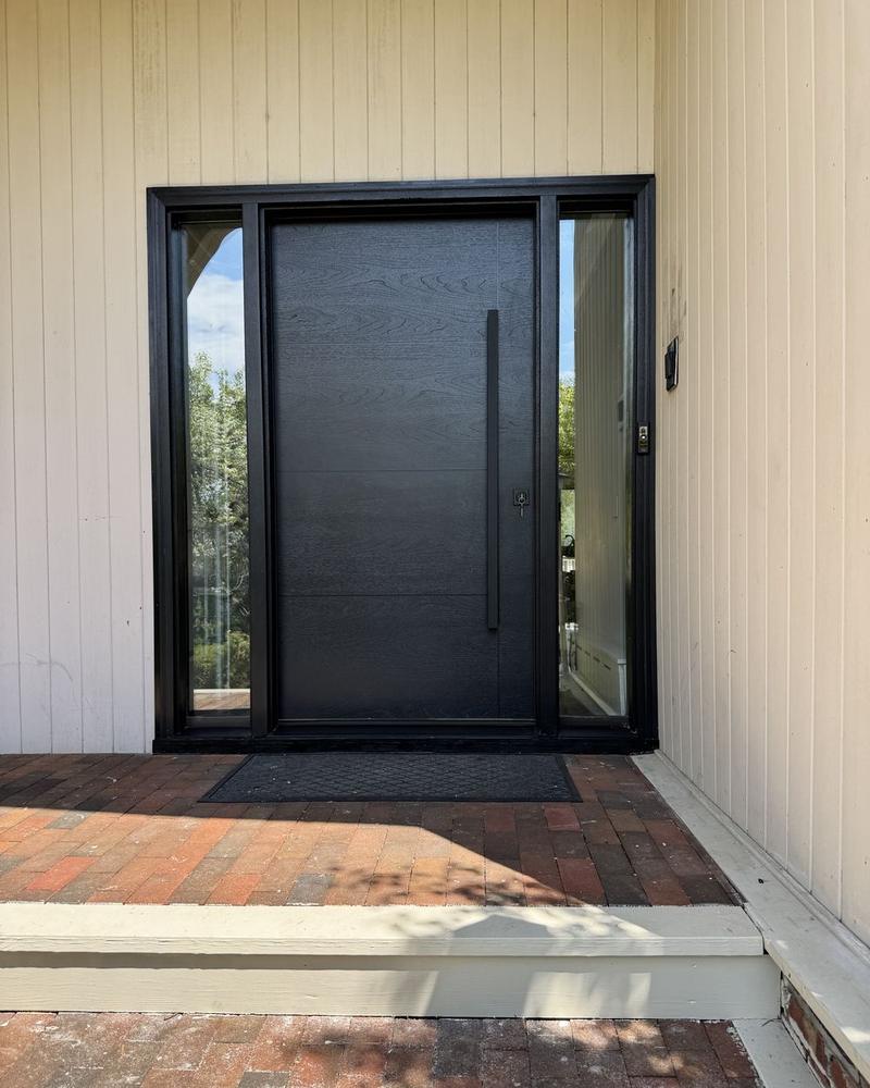 Single black entry door with a sidelight on a cream-sided house