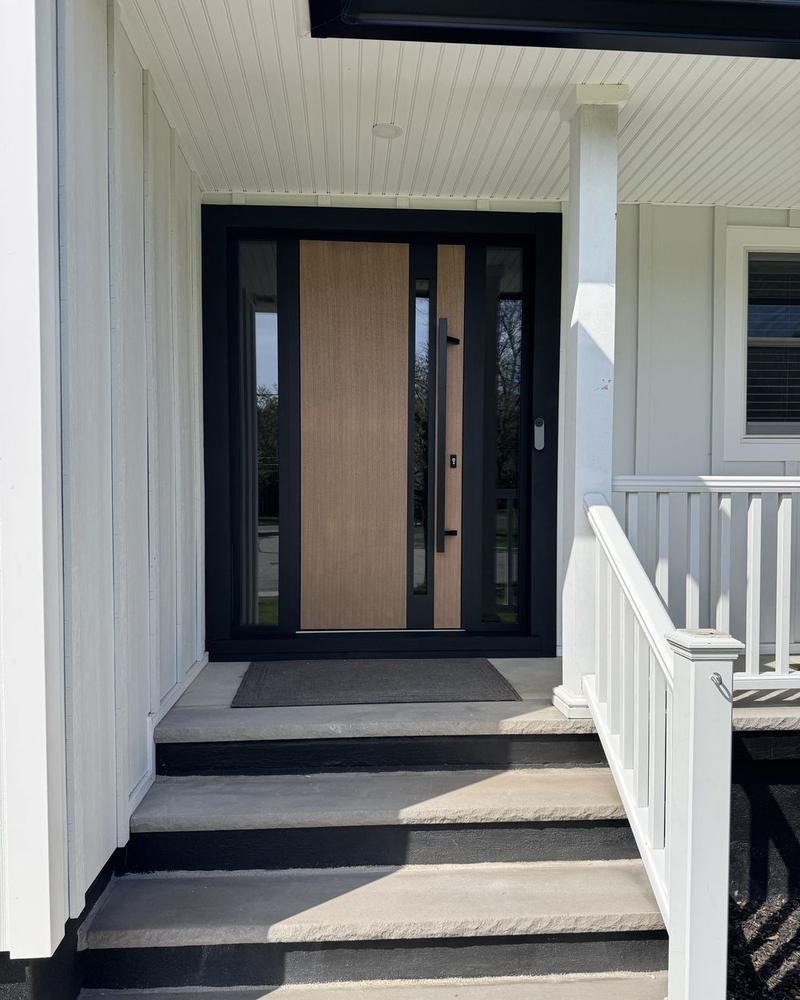 Wood-panel entry door with a black frame and sidelights