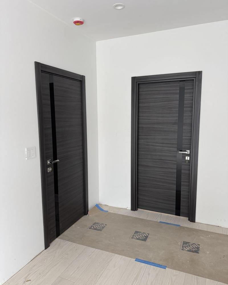 Two gray laminate interior doors with a vertical black inlay