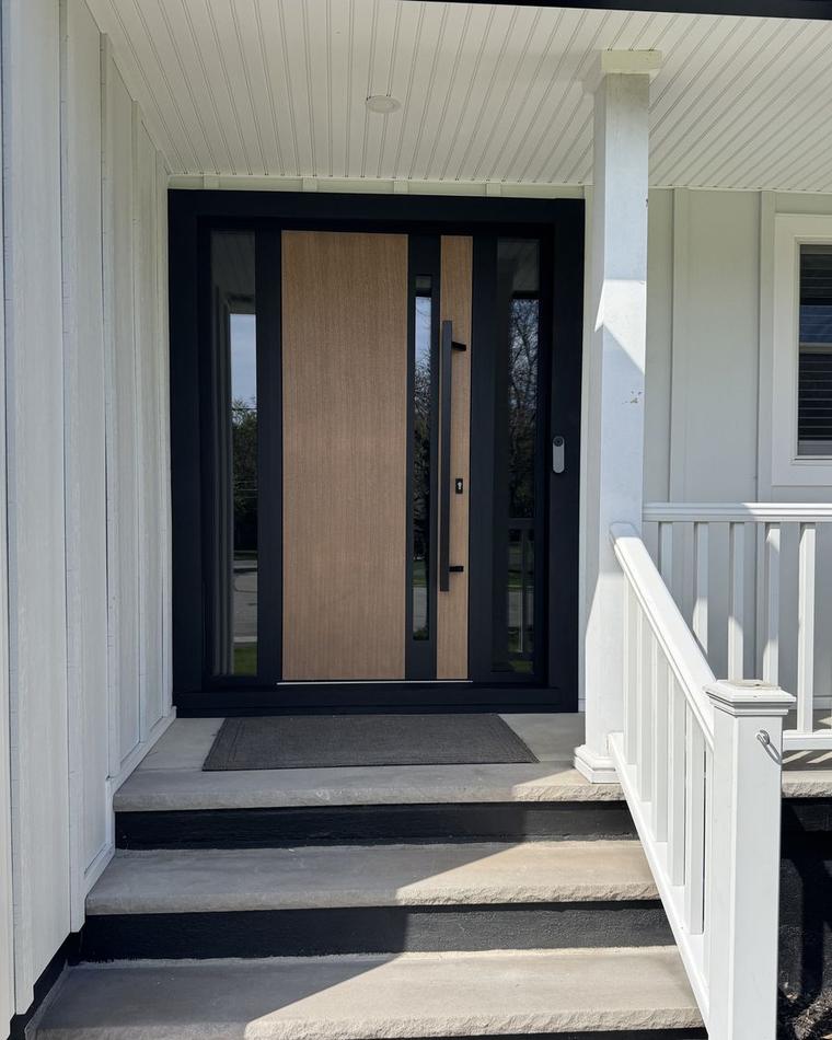 Wood-panel entry door with a black frame and sidelights, just installed