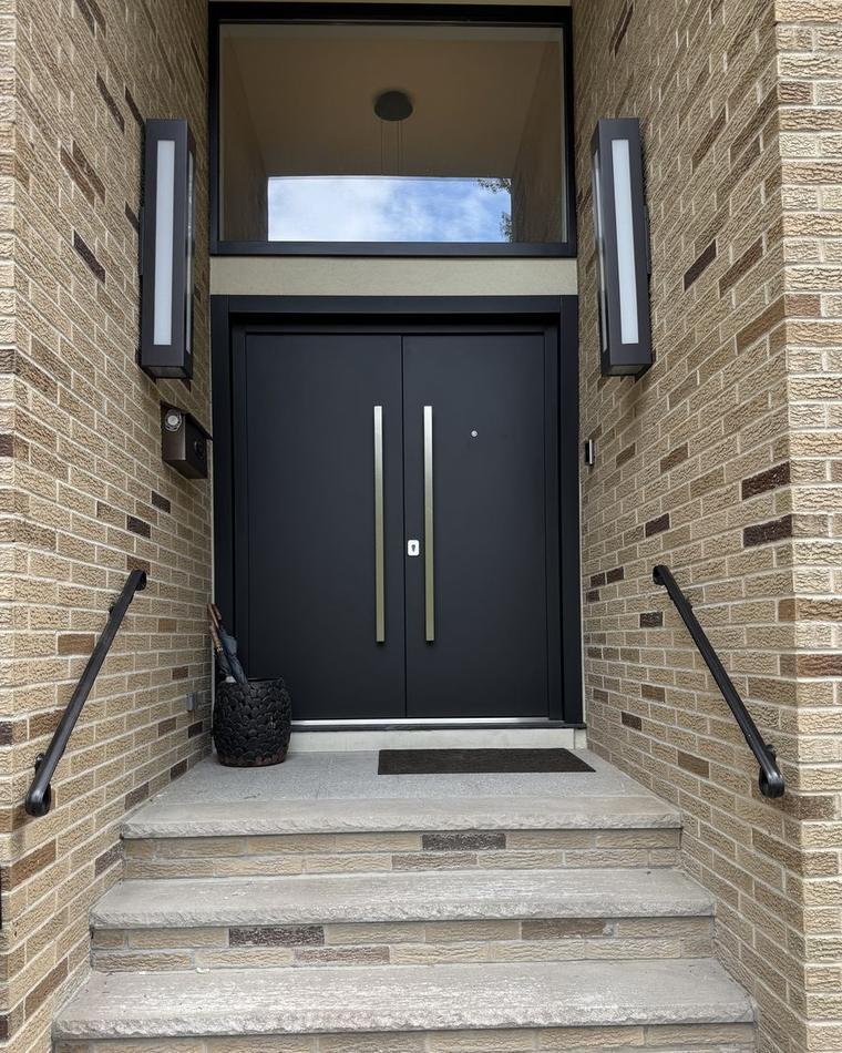 Full-height stainless pulls on a black double entry door